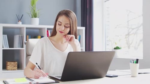Junge Frau arbeitet im Home-Office am Computerarbeitsplatz einer Unternehmerin, Freiberuflerin oder