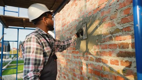 Man Applying Mortar to a Brick Wall