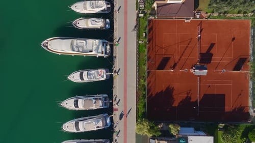Aerial Video Scenic View of a Tennis Club Surrounded By White Yachts and Bright Blue Water in a