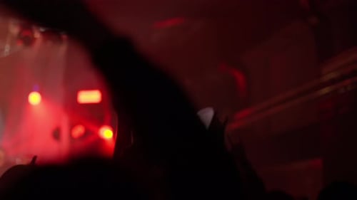 Concert Crowd Cheering Hands Up Under Red Stage Lights