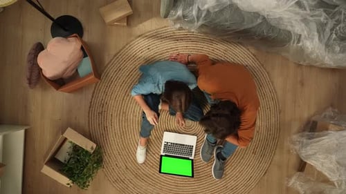 Top View Couple Sitting on the Floor Looking at Laptop with Chroma Key Green Screen Happy Expression