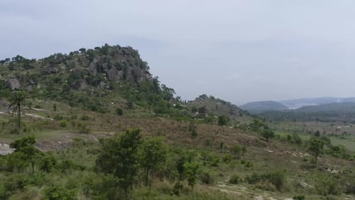 Drone shot 2 mountain peaks in the horizon amongst a valley of trees