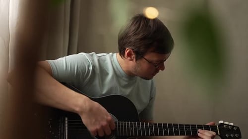 Man Playing Acoustic Guitar Indoors