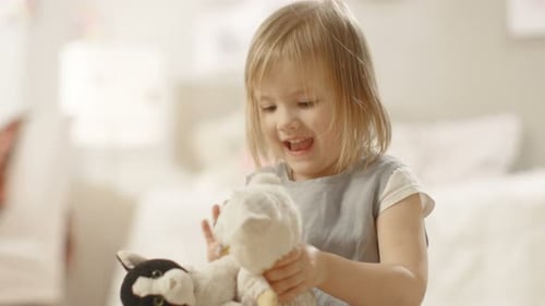 Child Playing with Stuffed Animals and Laughing