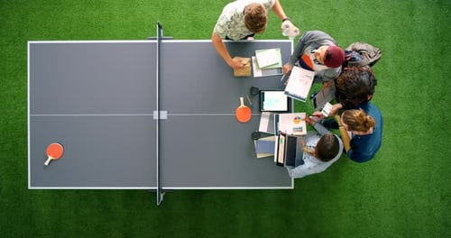 Team Collaborating at Ping Pong Table in Modern Office