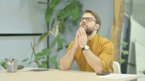 Pensive Young Man Thinking while Sitting in Office