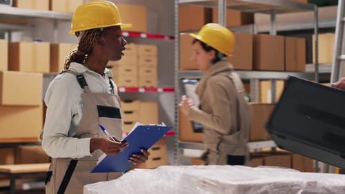 Warehouse Workers Inspecting Items and Taking Notes
