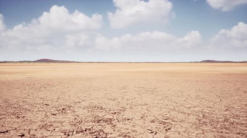 Moving Clouds Over Arid Desert Landscape with Cracked Earth