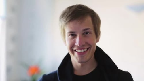 Smiling young adult man looking at the camera