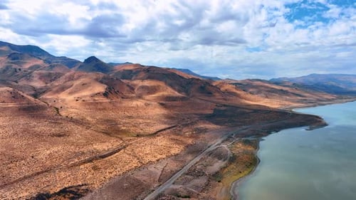 River, desert and bare mountains. Cloudscape covers the blue sky over the West Crystal, Utah, USA