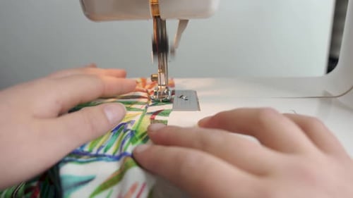 Close-Up Sewing Machine Stitching Colorful Patterned Fabric