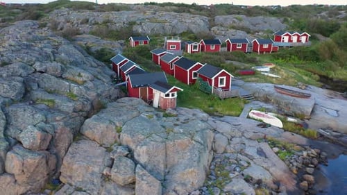 Aerial view of red cabins on rocky terrain, Sweden.