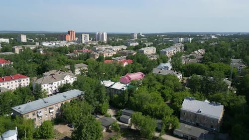 Aerial View Panning Over a Residential District with Colorful Rooftops and Green Trees Clip