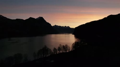 Crimson skies over Walensee, serene dawn. Switzerland aerial