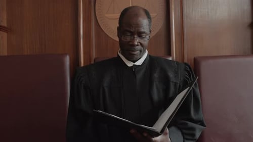 Judge Reading Documents in Courtroom Setting