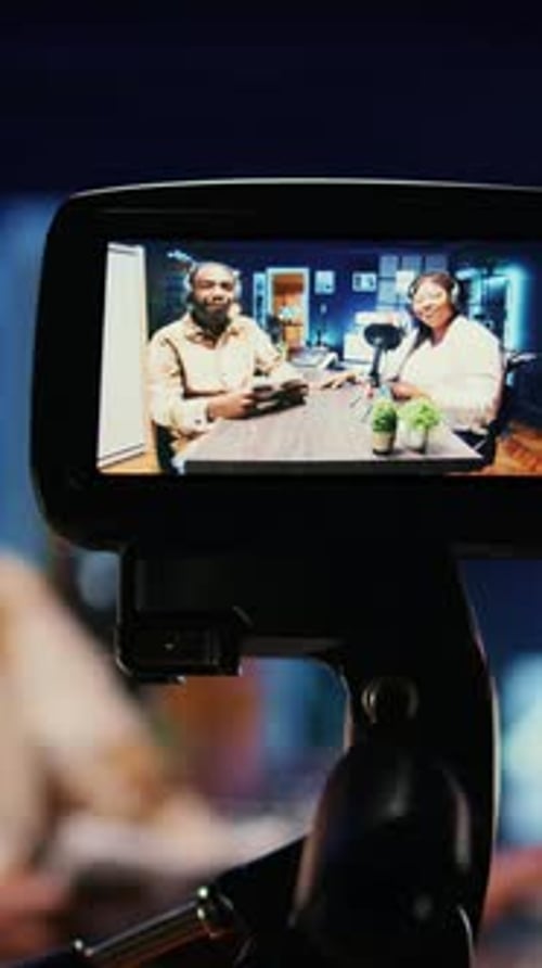 Vertical Video Focus on Vlogging Camera Used By Cohosts in Blurry Background Streaming Podcast