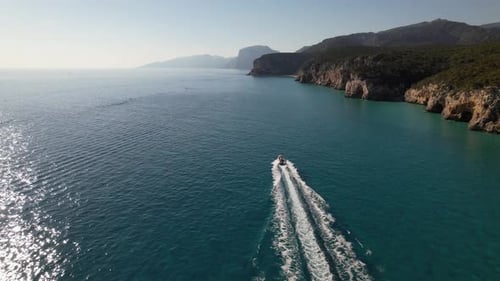 Boat drives along the coast at full speed.