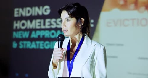 Woman Speaking at a Corporate Event About Homelessness