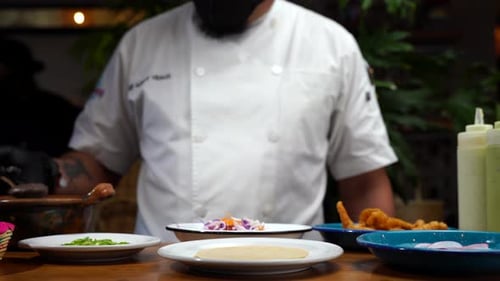 Chef adding beans on top of tortilla in mexican restaurant