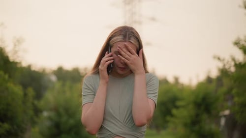 Exhausted Woman on Phone Call Outdoors Showing Frustration