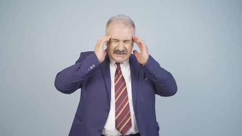 Stressed Man Massaging Temples with Headache