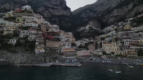 Aerial video of the colorful villas of Positano, on the cliff side with boats on the ocean, Italy