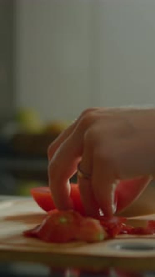 Hand Carefully Slices Red Tomato on Wooden Cutting Board