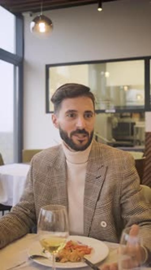 Portrait of businessman sitting with coworkers in restaurant, talking during business lunch.