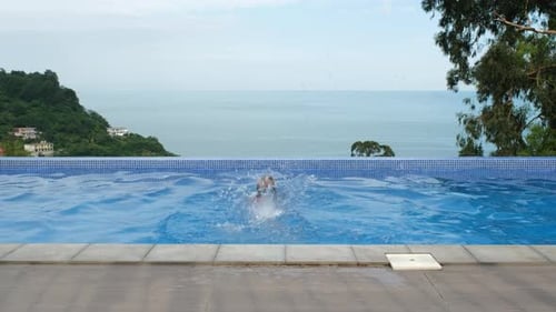 Little Girl Swimming in Infinity Pool By the Sea