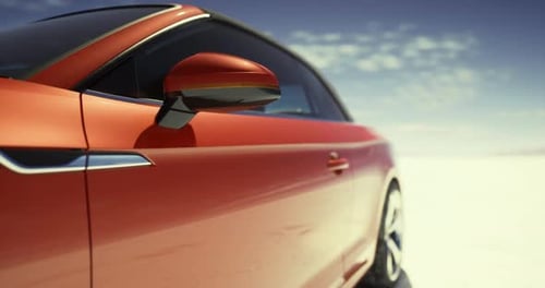 Sleek Red Sports Car Driving Across a Vast Desert Landscape