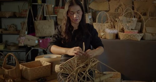 Une artisane asiatique qui est une villageoise rurale qui tisse des paniers folkloriques et des sacs tissés pour femmes