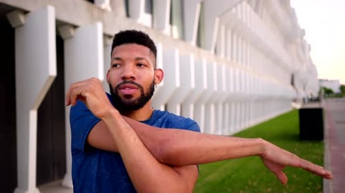Man Stretching Arms Before Workout in City