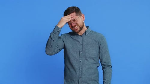 Man Rubs Temples Experiencing Headache Pain