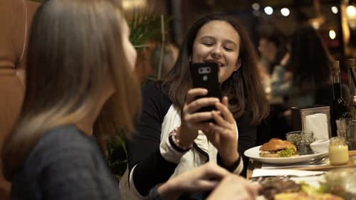 Funny Teenage Girlfriends Taking Photos With Cellphone In Cafe