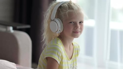 Girl Listening to Music on Headphones Indoors