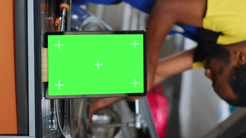 Vertical Video Car Mechanic Next to Green Screen Tablet