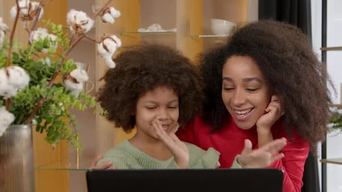Smiling Child and Adult Use Laptop Together