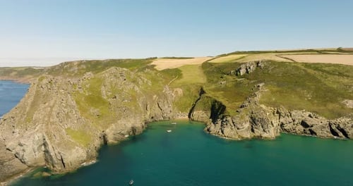Rocky Coastline Dramatic Cliffs Over Sandy Bay With Fishing Boats Aerial View