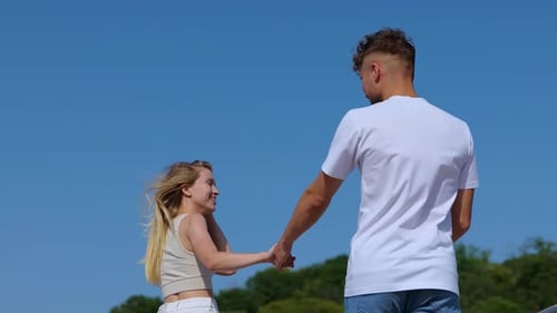 Happy Couple Holding Hands Walking Outdoors Toward Camera