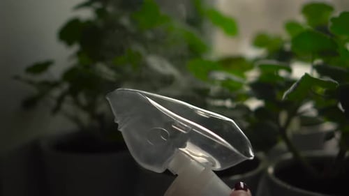 Inhalation Mask Closeup on a Background of Green Flowers Steam is Coming Out of the Mask Slow Motion