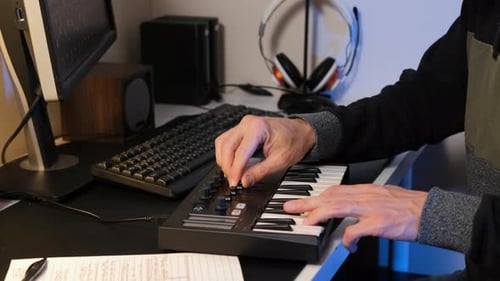 Music Producer Works on Track with MIDI Keyboard