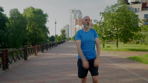 Active Sporty Fit Middle Aged Man Preparing for Morning Run Outdoors