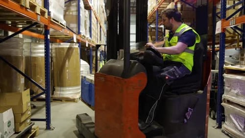 Forklift Driver Driving A Pallet In A Warehouse