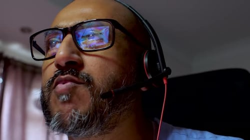 Comerciante del sur de Asia que trabaja desde casa con auriculares