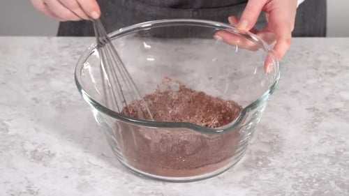 Hands Mix Dry Baking Ingredients in Glass Bowl
