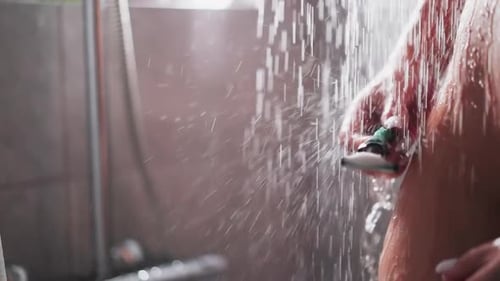 Woman Shaves Leg with Razor in Shower