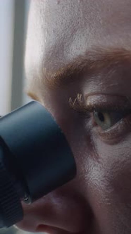 Close Up of Eyes of Female Doctor Looking Under Microscope