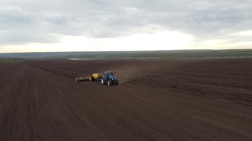 Blue tractor OA working on the field in Ukraine