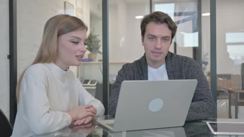 Business Professionals Collaborating on Laptop in Office