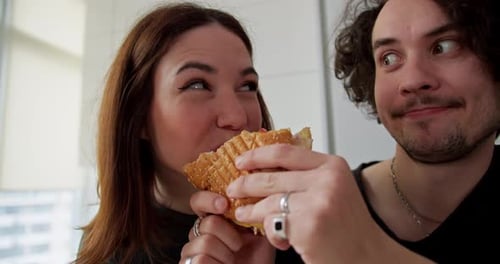 Affectionate Couple Sharing Delicious Sandwich in Kitchen